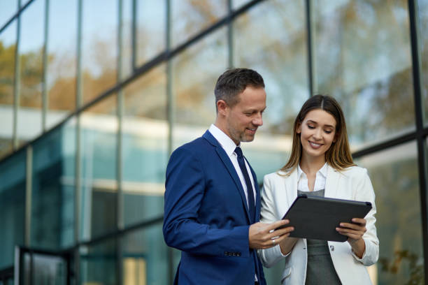 istock Business couple working online outdoors on a tablet computer 1328971368