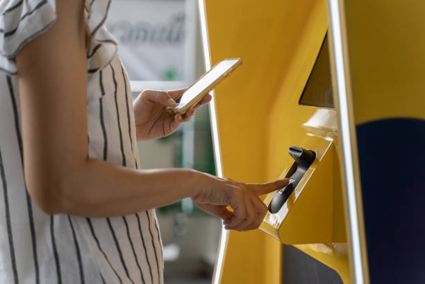 Close-up woman hand paying with mobile phone at automatic vending machine Close-up female hand paying with digital wallet on mobile app at automatic vending machine. Woman using smartphone and fingerprint recognition technology to withdraw cash from ATM. fingerprint scanner photos stock pictures, royalty-free photos & images
