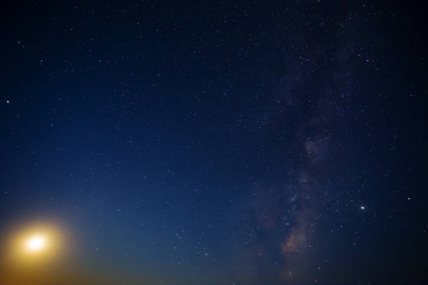 istock night starry sky with milky way and rising moon 1328973893