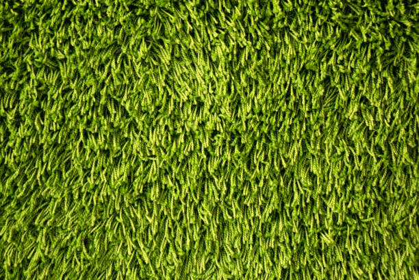 Green background made of artificial threads .Green fabric texture and pattern for background