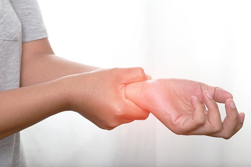 Female holding hand to spot of wrist pain,wrist pain
