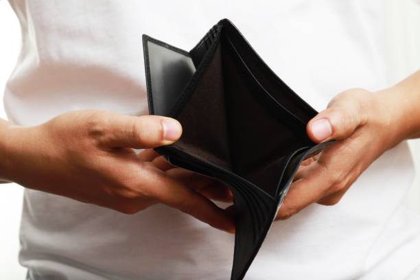 istock Man opens an empty leather wallet with no money in an empty pocket. Very poor. 1328979397