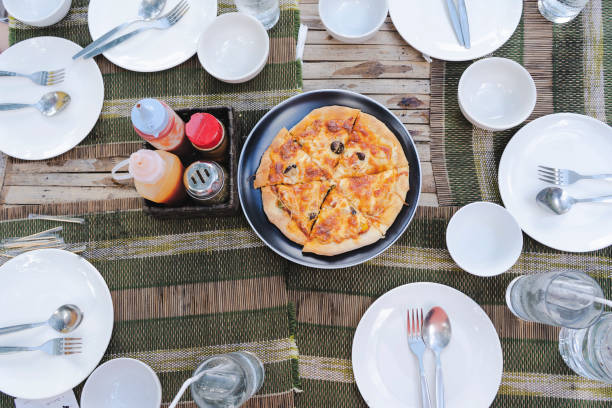 istock dinner table with many white dishes, along with pizza trays. 1328982255