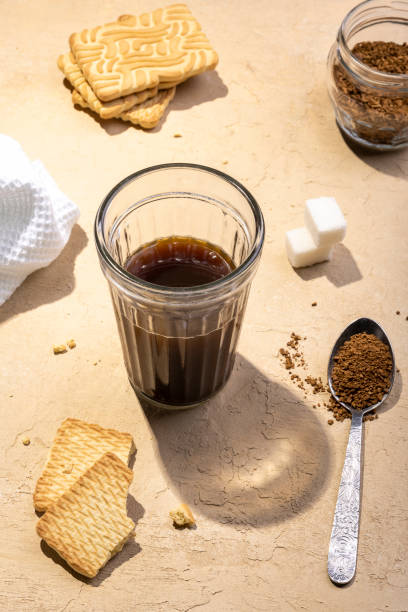 nahaufnahme des morgendlichen instantkaffees mit eisenlöffel und keksen auf einem holztisch - snack coffee instant coffee cappuccino stock-fotos und bilder