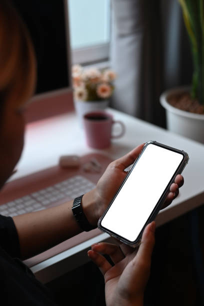 istock Close up view female sitting at office desk and using mobile phone. 1328984311