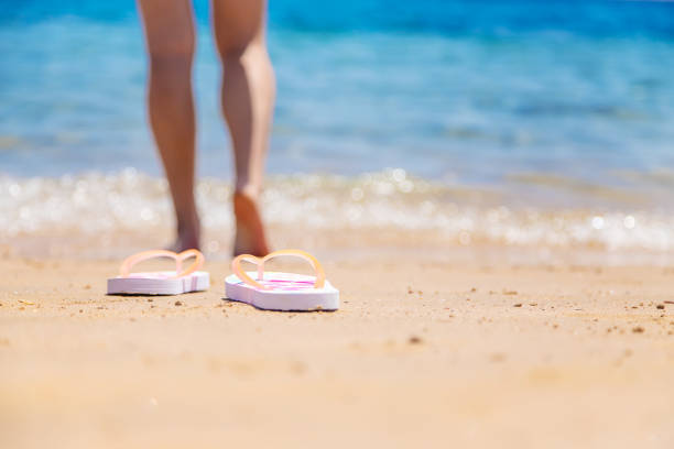 istock Woman's legs on the beach near the sea. Selective focus. 1328987214