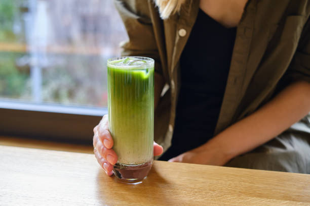 女の子は日本の冷たいアイスラテと緑の抹茶を飲みます。暑い日は夏の飲み物。ミルクまたは野菜ミルクと伝統的な抹茶。アイスドリンク - milk shake coffee latté cold ストックフォトと画像