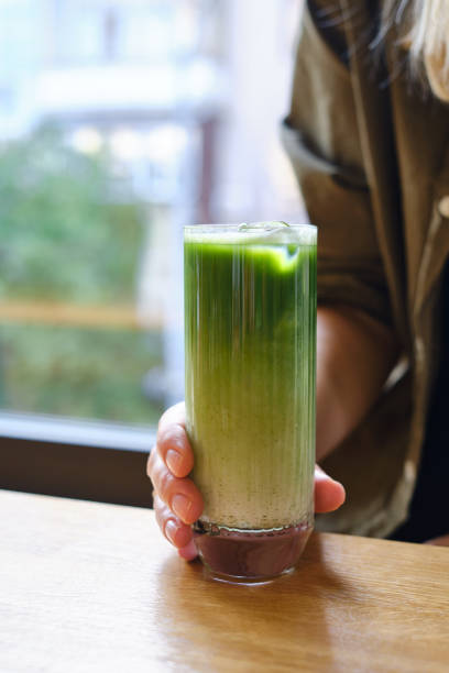 女の子は日本の冷たいアイスラテと緑の抹茶を飲みます。暑い日は夏の飲み物。ミルクまたは野菜ミルクと伝統的な抹茶。アイスドリンク - milk shake coffee latté cold ストックフォトと画像