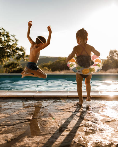 istock Playful siblings having fun during summer day at the pool. 1328989208