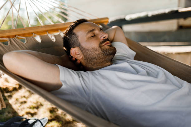 istock Relaxed man taking a nap in hammock. 1328989222
