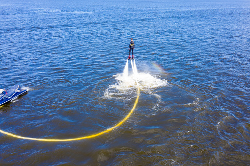 Man on the flyboard. Flyboard view from drone. Aerial view of water extreme action sport. Guy is flying at the aquatic flyboard