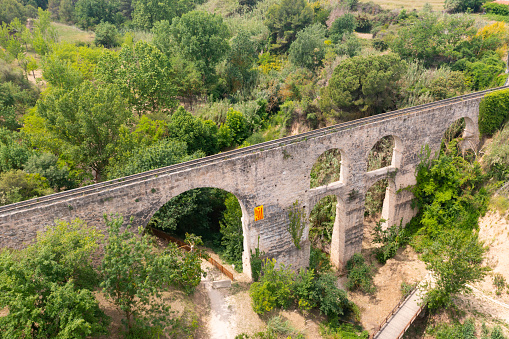 Scenic view from drone of medieval arched aqueduct in Sant Pere de Riudebitlles village in Spain on summer day