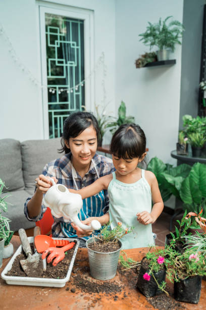 istock mother and daugther watering her plants 1328995170