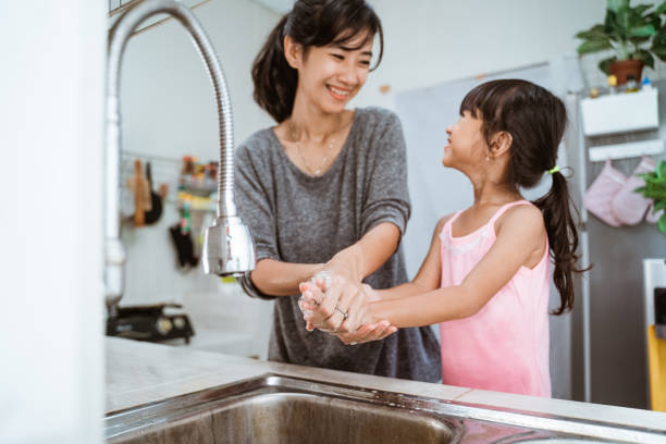 istock mother and daughter wash their hand 1328996211