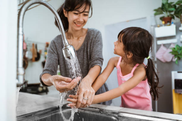 istock mother and daughter wash their hand 1328996221