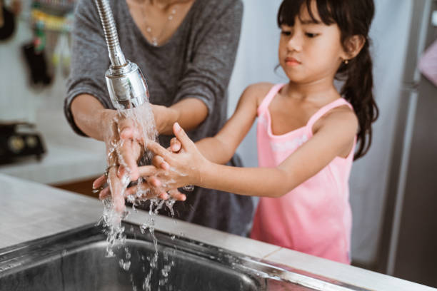 istock mother and daughter wash their hand 1328996251