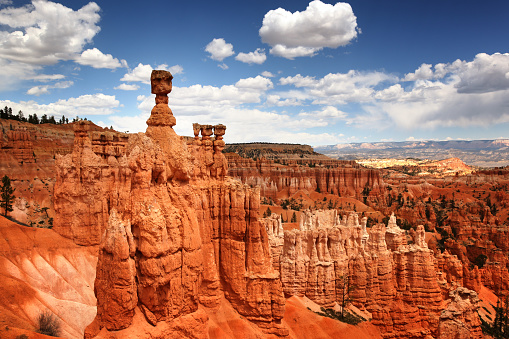 Female hiker admiring Bryce national park in winter with light snow and hoodos all around in Utah, United States