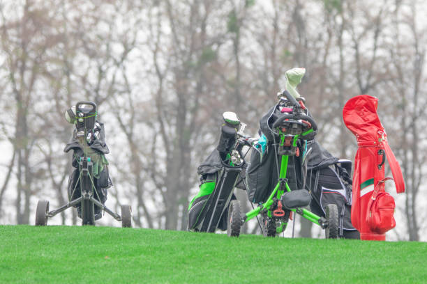 clubs de golf dans un sac sur une voiturette sur un terrain de golf. - golf golf course swinging isolated photos et images de collection