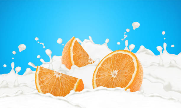 Cutted orange in milk splashes isolated on a blue background.