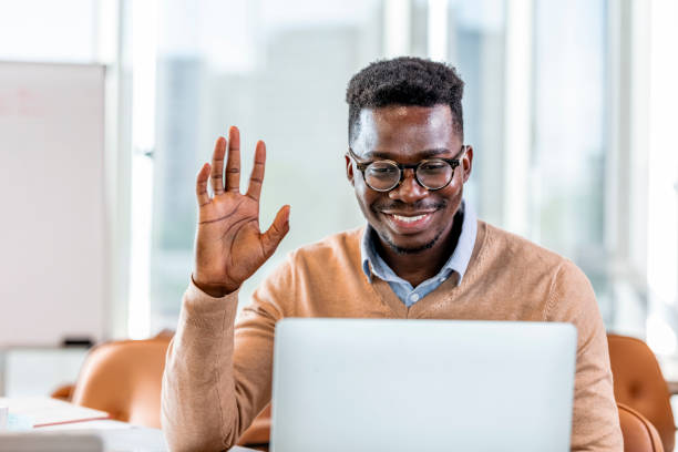 istock Young man waving with hand on video call at office 1329000557
