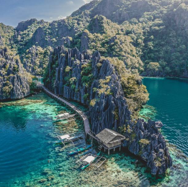 bateaux traditionnels sur une jetée en bois sur l’île de coron, lagon jumeau, philippines - visayan islands photos et images de collection