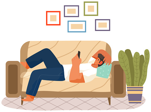 Man is lying on couch and holding phone in hand. Rest, free time, leisure concept. Guy looks at smartphone screen. Person communicates or works on mobile device. Male character resting with phone