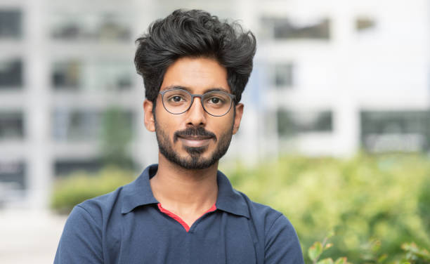 Handsome young man looking at camera Smiling indian student man portrait in a city. People, male beauty, city life, lifestyle concept 20 29 years stock pictures, royalty-free photos & images