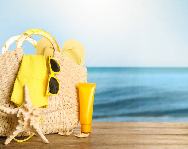 istock Different beach objects on wooden surface near sea, space for text 1329003829