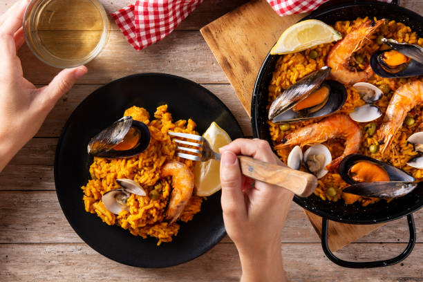 istock Woman eating spanish seafood paella 1329004587
