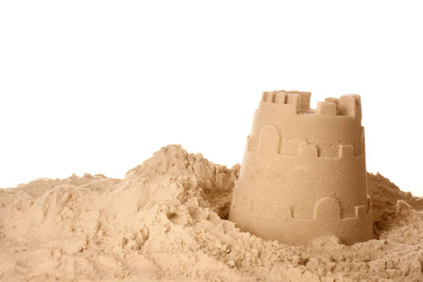замок из песка на белом фоне. игра на открытом воздухе - sandcastle стоковые фото и изображения