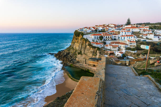 Azenhas do Mar, typical village on top of oceanic cliffs, Portugal Typical Portuguese village Azenhas do Mar on top of oceanic cliffs at sunset, Portugal azenhas do mar stock pictures, royalty-free photos & images