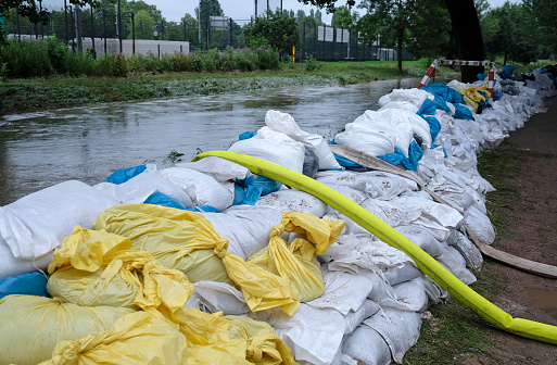 Extreme weather - a line of sand bags and hoses to pump water out of flooded basements in Düsseldorf, Germany
