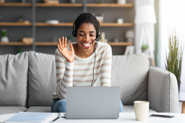 istock Online Communication. Cheerful Black Female In Headset Making Video Call On Laptop 1329006336