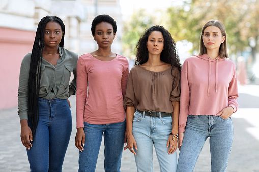 Multiracial group of millennial women in casual standing on the street, having strike. Young multiethnic ladies protestors fighting for women rights. Feminism, womens equality day concept