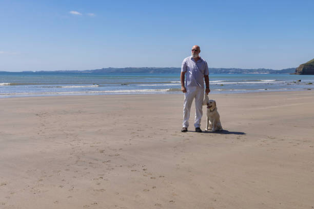 istock Man and his dog on a beach in West Wales 1329009070