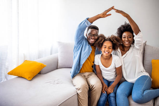 Concept of housing and relocation. Concept of housing and relocation. Happy family mother father and kids with roof at home. New building residential house purchase apartment concept. Concept housing young family. african american architecture stock pictures, royalty-free photos & images
