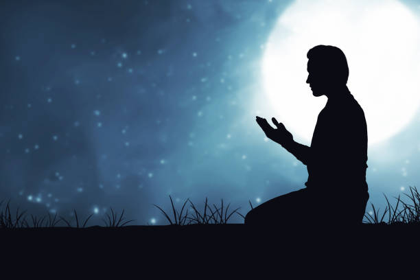 istock Silhouette of Muslim man sitting while raised hands and praying 1329012800