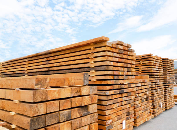 stack of lumber and planks in a lumber warehouse outdoors - timber imagens e fotografias de stock