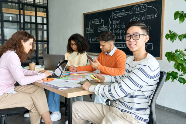 istock Four multiracial cheerful happy students studying together in classroom. 1329013220