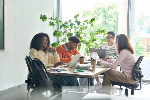 four happy colleagues creative team working together in office using devices. - letter z imagens e fotografias de stock