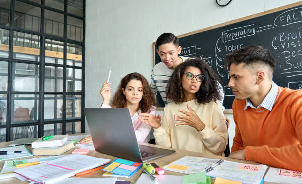 istock Four diverse coworkers brainstorming discussing project in contemporary office. 1329013256
