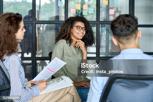 istock Diverse smiling happy colleagues listening to mentor leader in modern office. 1329013291