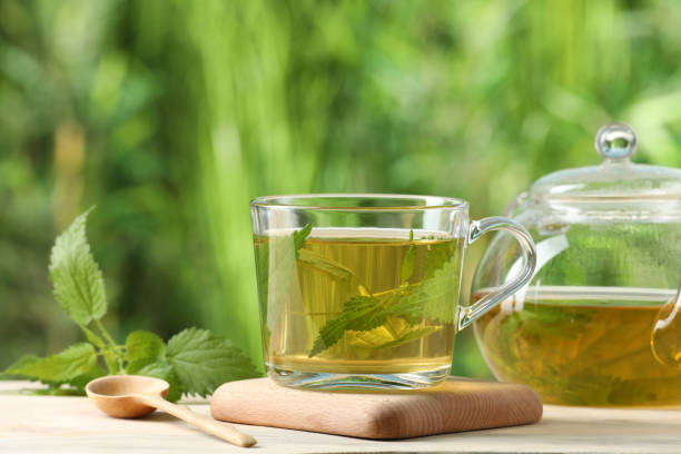 istock Aromatic nettle tea and green leaves on table outdoors 1329014036