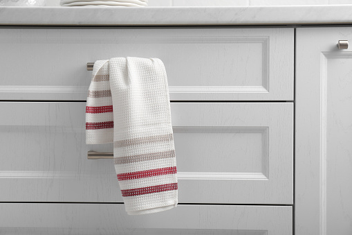 Soft kitchen towel hanging on drawer handle indoors