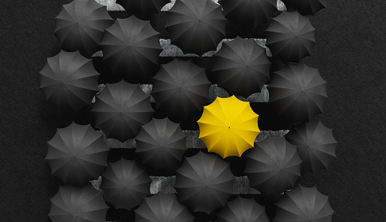 top view of black umbrellas over crosswalk crossing the road with yellow umbrella standing out. 3d render