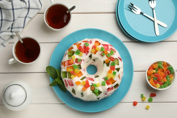 Delicious broken glass jelly cake on white wooden table, flat lay
