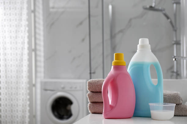 istock Stack of folded towels and detergents on white table in bathroom, space for text 1329021086