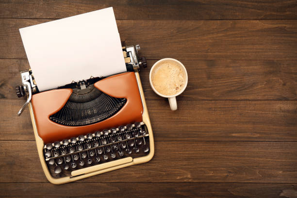 istock Vintage typewriter and cup of coffee on wooden table, flat lay. Space for text 1329021167