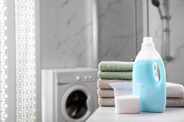 istock Stack of folded towels and detergents on white table in bathroom, space for text 1329021207
