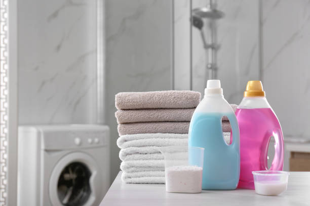 pila de toallas plegadas y detergentes en la mesa blanca en el baño - washing fotografías e imágenes de stock